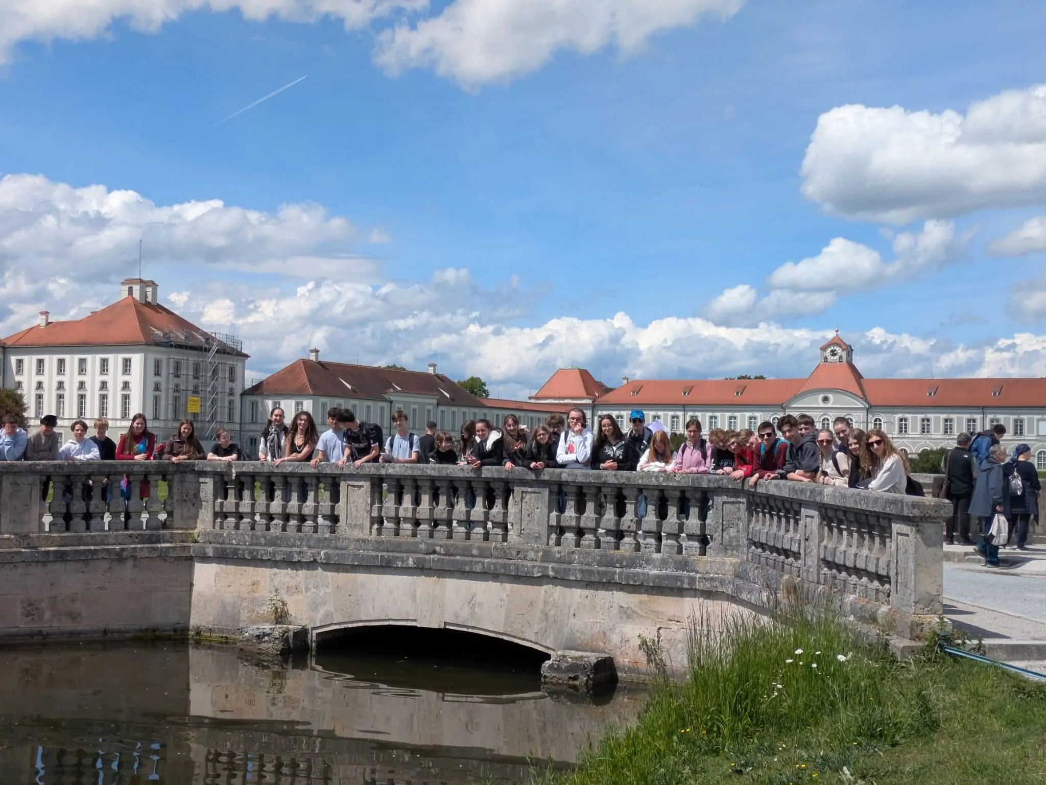 Les élèves du collège Saint-François de Bouvigny-Boyeffles alignés sur un pont en pierre devant la magnifique façade du château de Nymphenburg, pendant leur séjour à Munich.